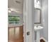 Half bathroom features a pedestal sink, mirror, and wood floors at 118 Hardy Water Dr, Lawrenceville, GA 30045