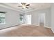 Bright bedroom boasts a ceiling fan, two windows, neutral walls and carpet at 118 Hardy Water Dr, Lawrenceville, GA 30045