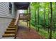 The stairs lead up to the wooden deck and overlook the wooded area at 118 Hardy Water Dr, Lawrenceville, GA 30045