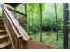 The stairs lead up to the wooden deck and overlook the wooded area at 118 Hardy Water Dr, Lawrenceville, GA 30045