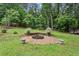 Backyard featuring a stone fire pit and lush trees, a relaxing space for outdoor gatherings at 1185 Wedgefield Sw Dr, Marietta, GA 30064