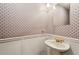 Charming powder room featuring patterned wallpaper, white wainscoting, and a pedestal sink at 1185 Wedgefield Sw Dr, Marietta, GA 30064