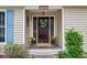 Elegant front entrance featuring a wooden door with glass panels, decorative wreath, plants, and stone tile flooring at 1185 Wedgefield Sw Dr, Marietta, GA 30064