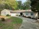 Inviting home exterior with a two-car garage, blue shutters, and a well-maintained front lawn with flowering shrubs at 1185 Wedgefield Sw Dr, Marietta, GA 30064