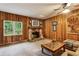 Cozy living room with stone fireplace, wood paneling, and natural light from the window at 1185 Wedgefield Sw Dr, Marietta, GA 30064
