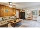 Open-concept living room with wood paneling, comfortable sofa, and view of the kitchen at 1185 Wedgefield Sw Dr, Marietta, GA 30064