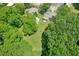 An aerial view of a home nestled amongst mature trees, featuring a large yard and detached garage at 1382 6Th Ave, Auburn, GA 30011