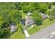 Aerial view of charming blue home with driveway, lush trees, and a large lot at 1382 6Th Ave, Auburn, GA 30011