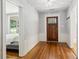 Entryway featuring hardwood floors, a wooden door, wainscoting, and a view into the bedroom, showcasing classic interior design at 1382 6Th Ave, Auburn, GA 30011