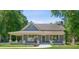 Charming blue home with a covered front porch surrounded by lush green trees and a well-manicured lawn at 1382 6Th Ave, Auburn, GA 30011