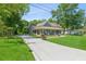 Long driveway leading to a charming home with a covered front porch, nestled among mature trees and lush landscaping at 1382 6Th Ave, Auburn, GA 30011
