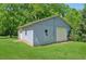Detached garage with a single-car door and side entrance, set against a backdrop of green lawn and mature trees at 1382 6Th Ave, Auburn, GA 30011