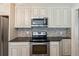Modern kitchen featuring stainless steel appliances, white cabinets, granite counters and stone backsplash at 1382 6Th Ave, Auburn, GA 30011