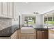 Close up of a kitchen featuring an eat-in island with granite counters, farmhouse sink and stainless dishwasher at 1382 6Th Ave, Auburn, GA 30011