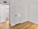 An airy, white-walled bedroom with a view to an ensuite bathroom featuring laminate flooring and minimalist decor at 1603 Cumberland Ct, Smyrna, GA 30080