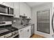 Updated kitchen features stainless steel appliances and stylish gray tile backsplash at 1603 Cumberland Ct, Smyrna, GA 30080