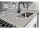 Close-up of kitchen sink with quartz countertop, stainless sink, and black faucet at 1603 Cumberland Ct, Smyrna, GA 30080