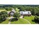 Stunning aerial view of a red barn style home with lush landscaping and golf course access at 411 Hickory Fairway Ct, Woodstock, GA 30188
