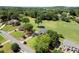 Aerial view of a home and neighborhood with a golf course in the distance at 411 Hickory Fairway Ct, Woodstock, GA 30188