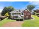 Expansive brick home with white trim, second-story balcony, and well-manicured lawn with mature landscaping at 411 Hickory Fairway Ct, Woodstock, GA 30188