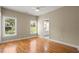 Spacious bedroom with hardwood floors, large windows offering natural light, neutral color scheme, and an attached bathroom at 411 Hickory Fairway Ct, Woodstock, GA 30188