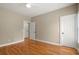 Bright bedroom with hardwood floors, neutral paint, ceiling fan, and multiple doors and windows, for ample natural light at 411 Hickory Fairway Ct, Woodstock, GA 30188
