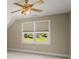 Cozy bedroom featuring neutral walls, a ceiling fan, and a window with views of the green outdoors at 411 Hickory Fairway Ct, Woodstock, GA 30188