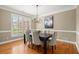 Dining room featuring hardwood floors, a modern chandelier, and plantation shutters at 411 Hickory Fairway Ct, Woodstock, GA 30188