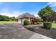 A winding driveway leads to a brick home with a two-car garage, surrounded by mature landscaping at 411 Hickory Fairway Ct, Woodstock, GA 30188