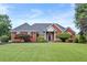 Charming brick home with lush lawn, manicured landscaping, and mature trees at 411 Hickory Fairway Ct, Woodstock, GA 30188