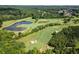 Scenic aerial view of a lush golf course with ponds, sand traps, and mature trees at 411 Hickory Fairway Ct, Woodstock, GA 30188