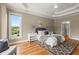 Peaceful main bedroom with hardwood floors, tray ceilings, and soft lighting, designed for relaxation and comfort at 411 Hickory Fairway Ct, Woodstock, GA 30188