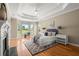 Serene main bedroom with tray ceilings, a bay window, and hardwood floors creating a relaxing retreat at 411 Hickory Fairway Ct, Woodstock, GA 30188