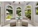 Bright sunroom with view of backyard pool and outdoor gazebo, featuring arched windows and neutral furniture at 1078 Shady Valley Ne Pl, Atlanta, GA 30324