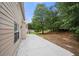 A large backyard features a large concrete patio and wooded area at 1486 Rogers Crossing Dr, Lithonia, GA 30058