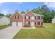 Charming two-story brick home with a well-maintained lawn and a two-car garage at 1486 Rogers Crossing Dr, Lithonia, GA 30058