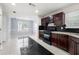 Well lit kitchen features tiled floors, dark wood cabinets and black appliances at 1486 Rogers Crossing Dr, Lithonia, GA 30058
