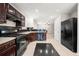 The kitchen showcases black appliances, dark wood cabinets, and a tiled backsplash at 1486 Rogers Crossing Dr, Lithonia, GA 30058