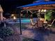Evening backyard featuring a pool, outdoor dining under string lights, and a fire pit at 1501 Laurelhill Drive Southwest Dr, Lawrenceville, GA 30044