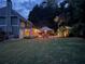 Twilight view of a backyard with a sparkling pool, outdoor dining area, and mature trees at 1501 Laurelhill Drive Southwest Dr, Lawrenceville, GA 30044