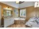 Bathroom with soaking tub, white cabinets, neutral walls, and tiled floors at 1501 Laurelhill Drive Southwest Dr, Lawrenceville, GA 30044