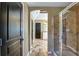 Hallway with view to bathroom featuring a tiled shower, tiled floor, and white vanity at 1501 Laurelhill Drive Southwest Dr, Lawrenceville, GA 30044