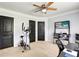 Spacious bedroom with black doors, ceiling fan, neutral carpet, and exercise equipment at 1501 Laurelhill Drive Southwest Dr, Lawrenceville, GA 30044