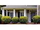Home featuring a welcoming covered front porch with decorative columns and meticulously trimmed shrubbery at 1501 Laurelhill Drive Southwest Dr, Lawrenceville, GA 30044