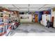Organized garage with storage bins, white cabinets, refrigerator, and a motorcycle at 1501 Laurelhill Drive Southwest Dr, Lawrenceville, GA 30044