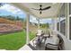 Inviting covered porch with comfortable wicker furniture and ceiling fan, overlooking the manicured backyard at 2445 Hidden Creek Rd, Kennesaw, GA 30152