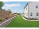 A landscaped backyard with a retaining wall, green grass, and an exterior view of the home at 2445 Hidden Creek Rd, Kennesaw, GA 30152