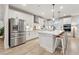 Bright, modern kitchen features white cabinetry, stainless steel appliances, a large island, and barstool seating at 2445 Hidden Creek Rd, Kennesaw, GA 30152
