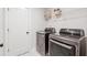 Convenient laundry room featuring modern washer and dryer, marble tile floors, and useful wall shelving at 2445 Hidden Creek Rd, Kennesaw, GA 30152