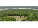 Panoramic aerial view of an estate nestled in a lush, wooded area near a tranquil lake at 615 Lovinggood Trl, Woodstock, GA 30189